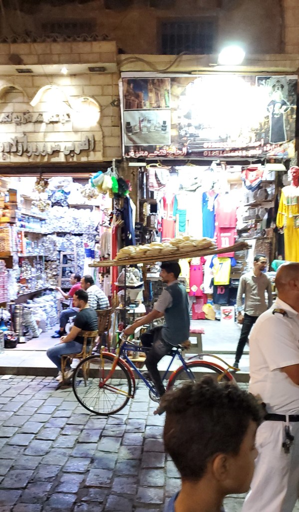 Bread sellers, usually young men on bikes transport large loaves of Egyptian bread known as aish baladi.