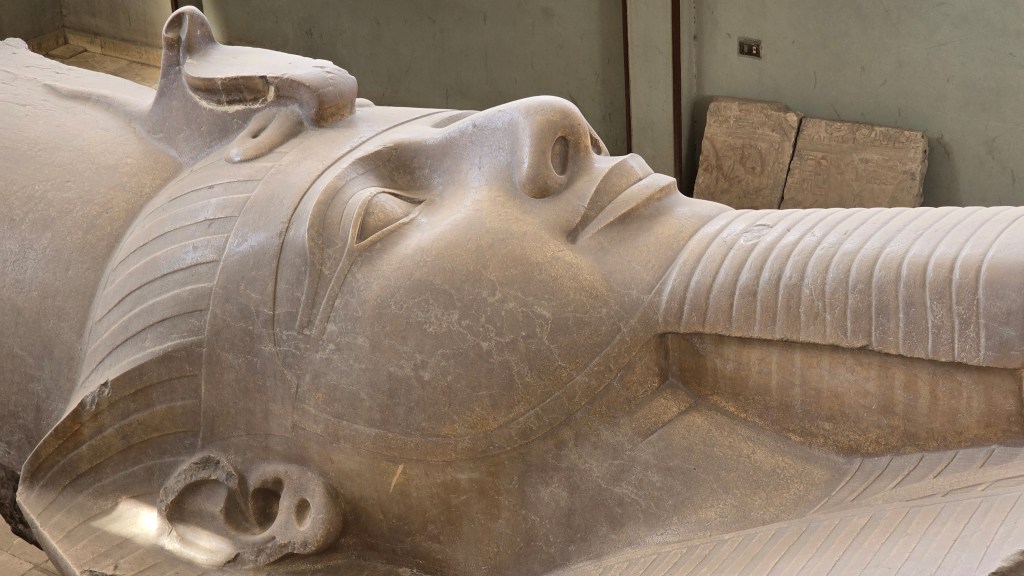 Enormous colossus of Ramses II, displayed lying on its back, giving you unique access to viewing its intricate detail, is displayed at the open-air museum of Memphis.